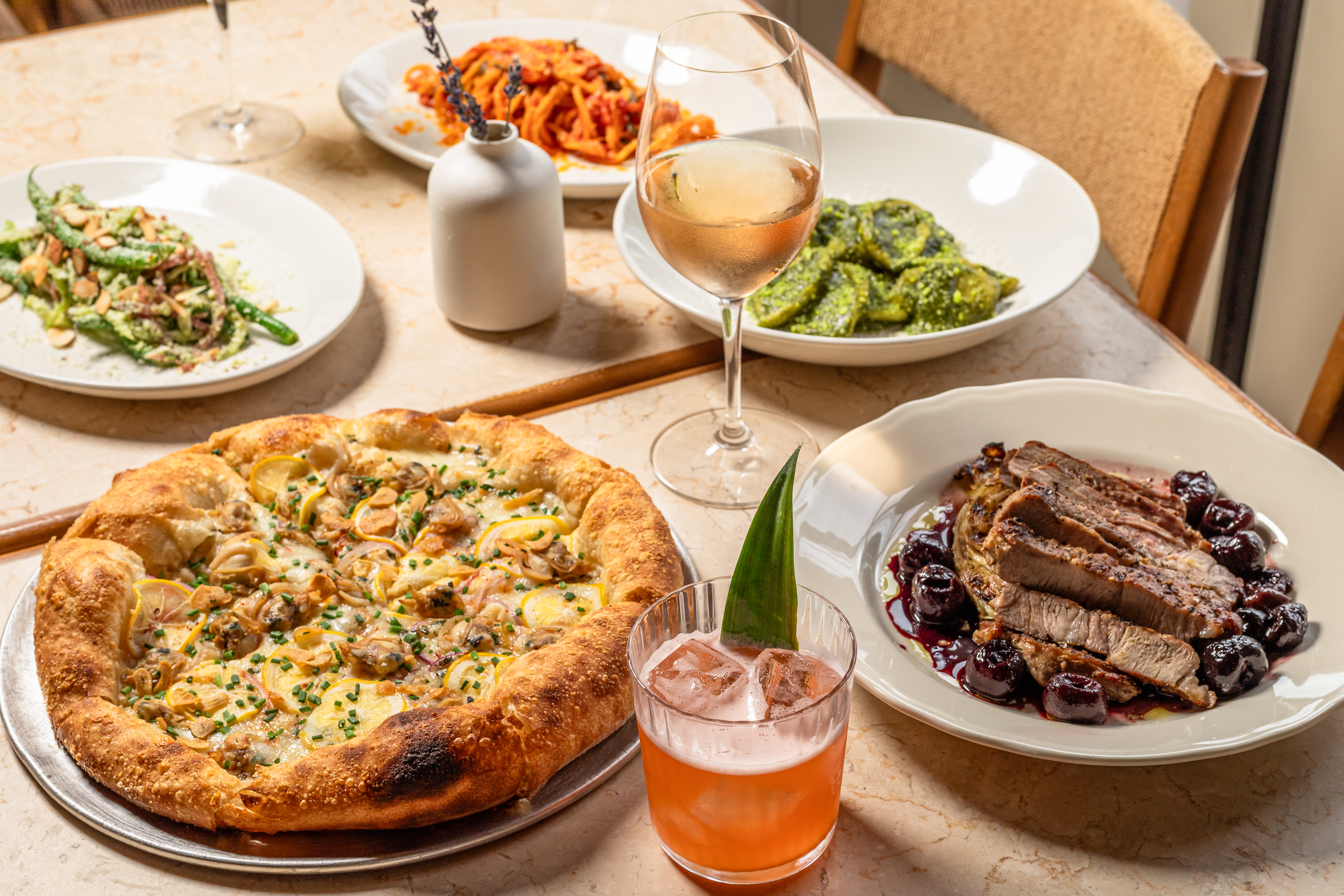 Table spread of pizza, pasta and shared plates