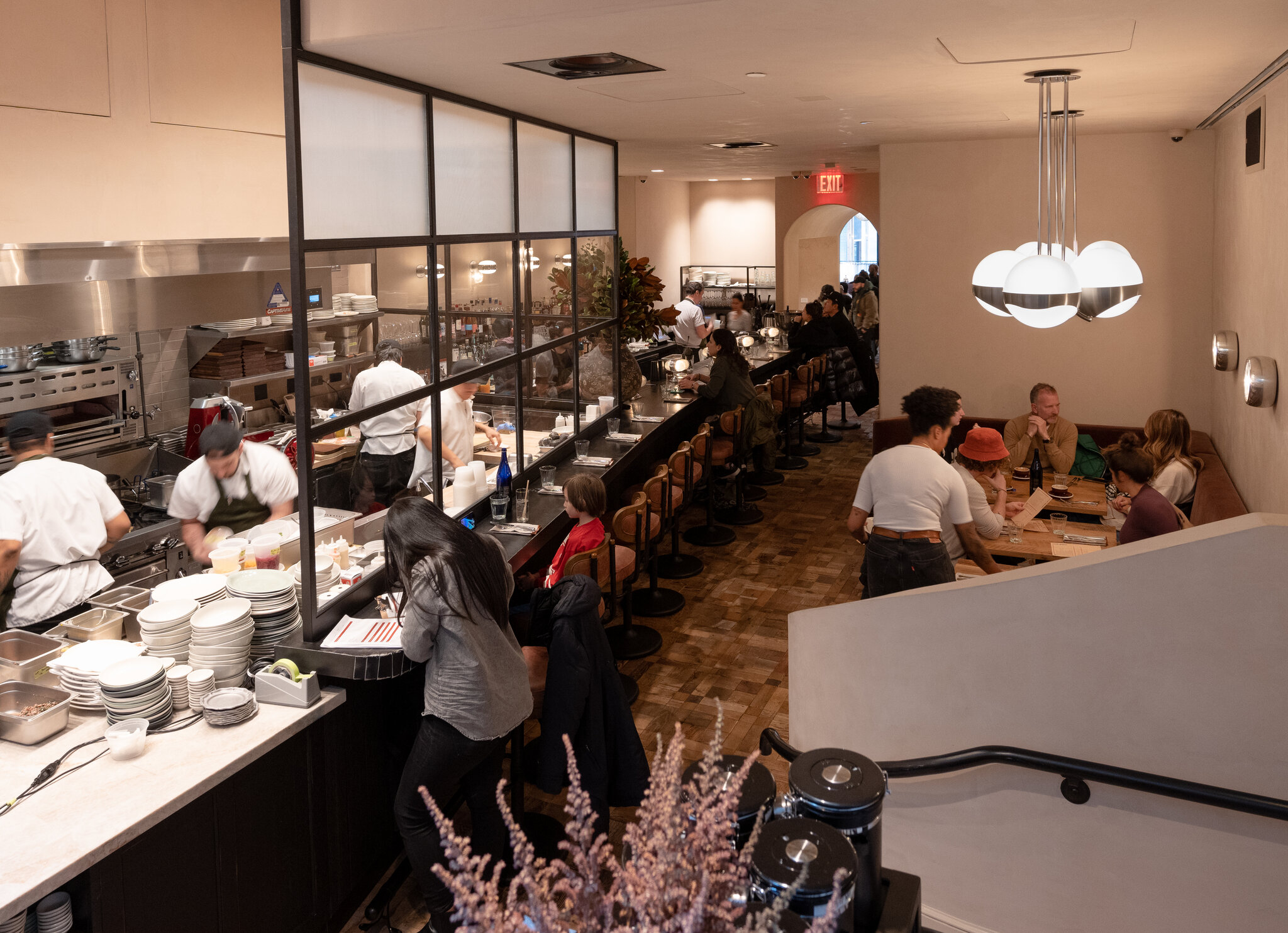 Open restaurant kitchen with cooks on the line and diners at the counter
